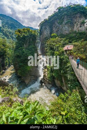 La chute d'eau El Pailón del Diablo et le pont avec les touristes sur la rivière Pastaza près de Baños en Équateur. Banque D'Images