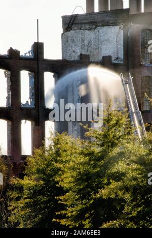 Le service incendie est en train d'éteindre des incendies dans un bâtiment en brique brûlée qui était une usine de textile historique à Columbus GA. Banque D'Images