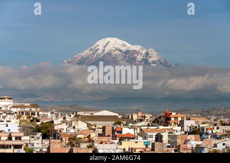 Mont Chimborazo volcan (6268 m) vu à travers les toits de la ville de Riobamba. Banque D'Images