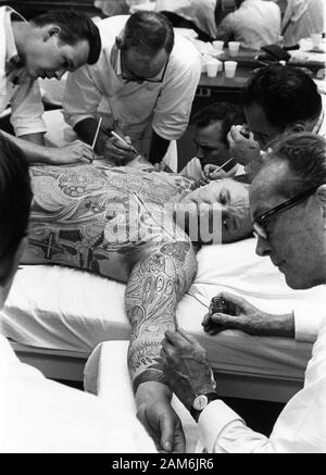 ROD STEIGER avec Make Up Artists painting tattoo images à son corps franc de production pendant le tournage de l'homme illustré 1969 Directeur Jack Smight livre Ray Bradbury SKM / Warner Bros / Seven Arts Banque D'Images