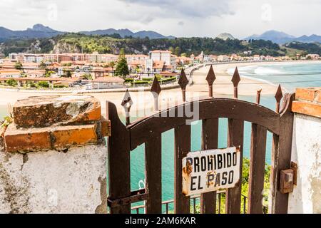 Ribadesella, Espagne. Un panneau de non-passage avec vue sur la ville côtière de Ribadesella dans les Asturies lors d'une chaude journée d'été Banque D'Images