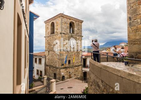 Lastres, Espagne. Photographe homme regardant la Torre del Reloj (Tour de l'horloge) Banque D'Images