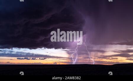 Paysage pittoresque avec un éclair vif et un ciel de coucher de soleil dans un orage près de Holbrook, Arizona Banque D'Images