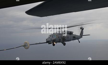 Un faucon de Pave HH-60 G affecté au 33ème Escadron de sauvetage effectue un ravitaillement en hélicoptère air-air avec un MC-130 J Commando II du 17ème Escadron des opérations spéciales au-dessus de l'océan Pacifique pendant l'exercice Westpac Rumrunner 10 janvier 2020. Westpac Rumrunner représente une évolution des actifs et des capacités de la 18ème Escadre à travailler avec des partenaires conjoints pour la défense des alliés américains et pour assurer une Indo-Pacific libre et ouverte. (ÉTATS-UNIS Photo de la Force aérienne par Sgt. Benjamin Sutton) Banque D'Images