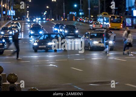 les gens qui marchent au-dessus du carrefour dans la rue de nuit de la ville. image floue Banque D'Images