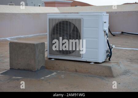 Climatiseur extérieur sur le toit d'une maison résidentielle. Contruction, bricolage, temps chaud, systèmes industriels, concepts. Banque D'Images
