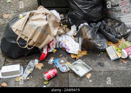 Londres, Royaume-Uni - 20 juillet 2019 : tas de déchets, y compris des paquets de cigarettes et des déchets alimentaires laissés sur un pavé à Southwark, dans le sud de Londres. Banque D'Images