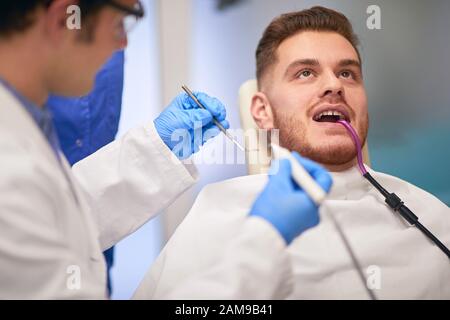 Gingembre barbu gars dans un cabinet dentaire ayant examiné ses dents Banque D'Images