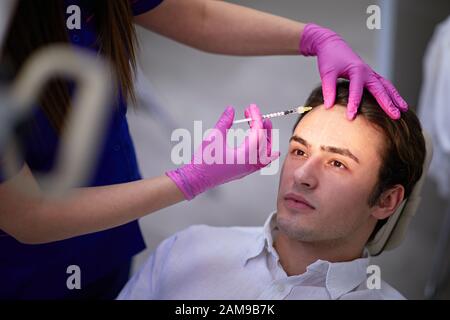 Homme ayant un traitement médical de rides avec injection de toxine botulinique Banque D'Images