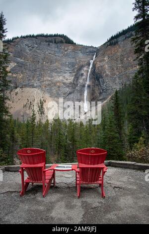 Chaises rouges devant les chutes Takakkaw dans le parc national Yoho Rocheuses canadiennes Banque D'Images