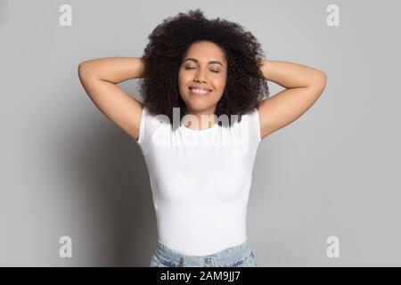 Souriante fille millénaires africaine heureuse qui s'étire, se détendant. Banque D'Images