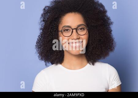 Sourire heureuse femme africaine américaine dans des verres regardant l'appareil photo. Banque D'Images