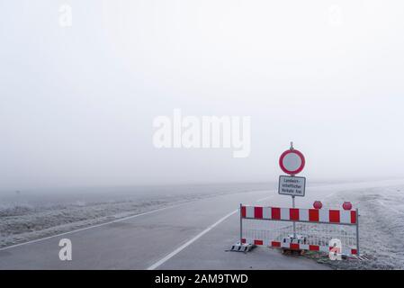 La route a fermé la barrière lors d'une journée froide de brume dans le sud de l'Allemagne. Paysage épais de brume. Panneaux d'avertissement sur route. Sécurité routière allemande Banque D'Images