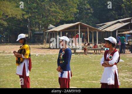 Chanda Bazar, Bongaon, Bengale occidental, Inde, 1 février, 2019 : trois filles de l'école en uniforme et casquette blanche et le bénévolat par lots Banque D'Images