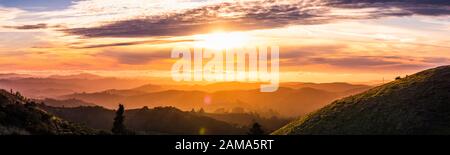 La lumière du soleil éclate à travers les nuages et éclairant les collines et vallées des montagnes de Santa Cruz; nuages couvrant le ciel et l'océan Pacifique; sa Banque D'Images