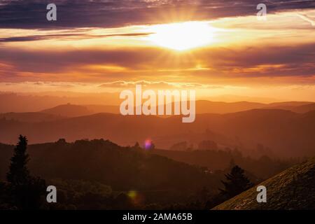 La lumière du soleil éclate à travers les nuages et éclairant les collines et vallées des montagnes de Santa Cruz; nuages couvrant le ciel et l'océan Pacifique; sa Banque D'Images