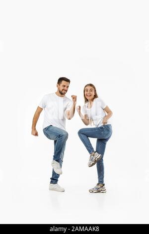 portrait complet d'un couple heureux dans une tenue décontractée dansant sur fond blanc Banque D'Images