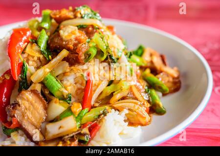 Gros plan de feuilles de basilic frit avec du porc croustillant sur le riz, de la cuisine locale thaïlandaise Banque D'Images