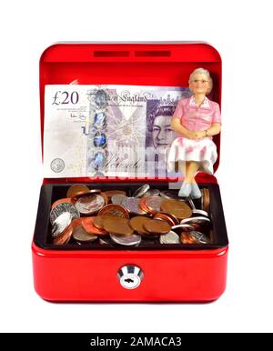 Une seule femme pensionnée figurine assise dans une caisse rouge, concept d'épargne-retraite Banque D'Images