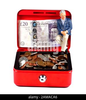 Une seule figurine masculine pour pensionné, assise dans une caisse rouge, concept d'épargne-retraite Banque D'Images