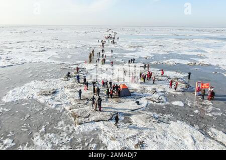 Panjin, Province Chinoise De Liaoning. 12 janvier 2020. Photo prise avec un drone UAV montre aux participants marcher sur la route de randonnée couverte de glace pendant un événement de randonnée sur glace à Panjin, dans le nord-est de la province de Liaoning en Chine, le 12 janvier 2020. Crédit: Pan Yulong/Xinhua/Alay Live News Banque D'Images