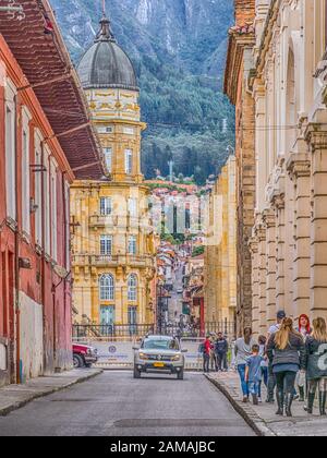 Bogota, Colombie - 28 novembre 2019: Rue de Bogota avec maisons coloniales colorées et vue sur la montagne en arrière-plan, le quartier de la Candelaria. Banque D'Images