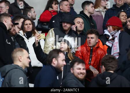 Joe Rodon (en veste orange) de Swansea City et du Pays de Galles est vu à l'extrémité opposée avec les fans de Swansea City avec Oli McBurnie de Sheffield Utd et l'Ecosse (chapeau noir/veste or). Match de championnat EFL Skybet, Cardiff City / Swansea City au Cardiff City Stadium le dimanche 12 janvier 2020. Cette image ne peut être utilisée qu'à des fins éditoriales. Utilisation éditoriale uniquement, licence requise pour une utilisation commerciale. Aucune utilisation dans les Paris, les jeux ou une seule édition de club/ligue/joueur. Pic par Andrew Orchard/Andrew Orchard sports photographie/Alay Live news Banque D'Images