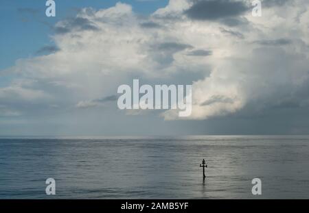 Une scène minimaliste classique de la mer, horizon bleu ciel et doucement des nuages en mouvement sans distractions prises dans la belle lumière Banque D'Images