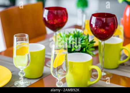 Gros plan de vaisselle sur la table. Plaques jaunes. Mugs verts. Verres à vin. Banque D'Images