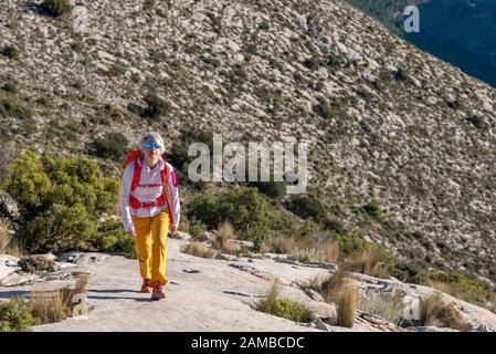 Des randonnées de femmes le long de ridgecrest longent la colline, la montagne El Divino, la province d'Alicante, Costa Blanca, Espagne Banque D'Images