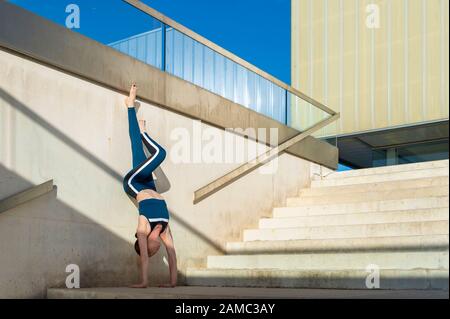 femme faisant une main sur les escaliers à l'extérieur, architecture moderne. Banque D'Images