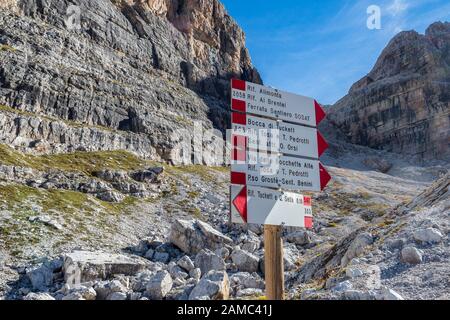 Indicateurs de direction du trekking. Itinéraires touristiques directions et temps de trajet indiqués sur les panneaux de direction traditionnels des Dolomiti montagnes, Italie Banque D'Images