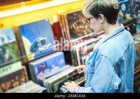 Jeune femme choisissant Vintage vinyl LP dans les dossiers Shop Banque D'Images