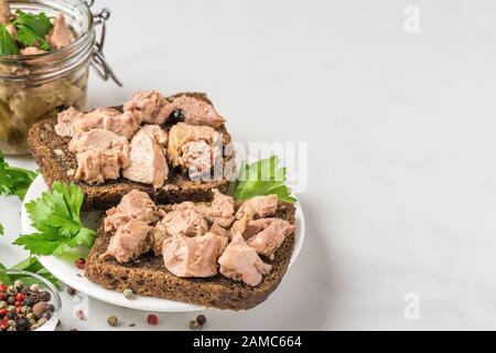 Foie de morue dans un pot avec sandwichs au foie sur fond blanc. Source naturelle d'oméga 3 et de vitamine D. proche de l'espace de copie Banque D'Images