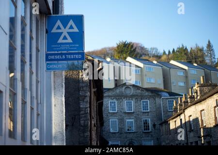 Panneau de la station de test de mot en métal bleu et blanc au-dessus d'un garage à Kendal, Cumbria, Royaume-Uni Banque D'Images