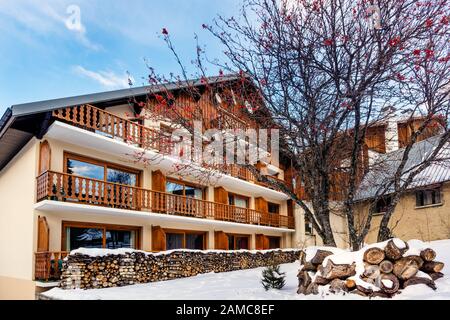 Les deux Alpes, Alpes, France, janvier 2017 piles de grumes devant une maison ou une cabane en bois traditionnelle alpine. Destination prisée pour les sports d'hiver et de ski Banque D'Images