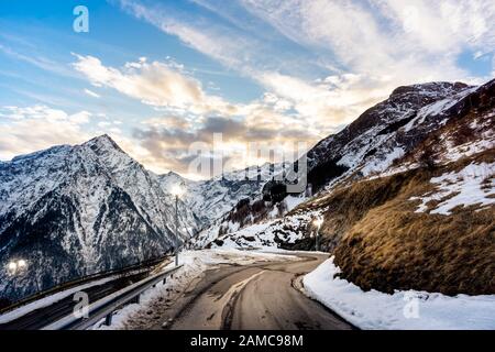 Vue depuis la périphérie du village des deux Alpes sur la chaîne de montagnes avec lampes de rue éclairées. Coucher de soleil sur les alpes françaises, région Auvergne Rhône, France Banque D'Images