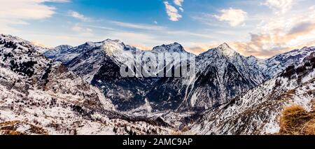 Vue depuis la périphérie du village des deux Alpes sur la chaîne de montagnes avec brouillard ou brouillard dans la vallée en contrebas. Coucher de soleil sur les alpes françaises, région Auvergne Rhône, France Banque D'Images