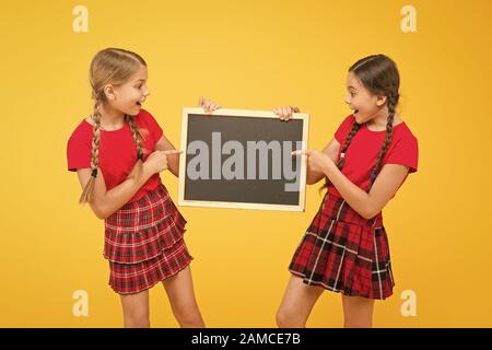 Cours de Cheerleading. Équipe de l'initiative de camarades. Inscrivez-vous le club scolaire. Les élèves de la communauté. L'annexe de l'école. School girls cute pupils uniforme rouge tenir copie tableau noir l'espace. Annonce école concept. Banque D'Images