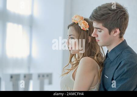 Guy hople fille de derrière. Couple amoureux de la lumière grande fenêtre le jour ensoleillé. Couple heureux célèbre la Saint Valentin Banque D'Images