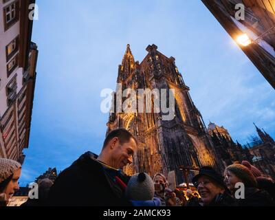 Strasbourg, France - 24 décembre 2018 : vue panoramique sur une famille heureuse souriant avec la cathédrale notre-Dame de Strasbourg en arrière-plan au crépuscule Banque D'Images