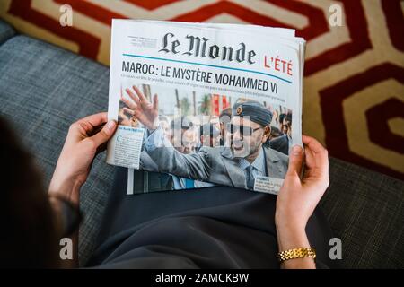 PAris, France - Aug 1, 2019 : POV Vue aérienne de femme lisant sur le canapé du salon français journal Le Monde avec le titre le mystère de Mohammed VI du Maroc Banque D'Images