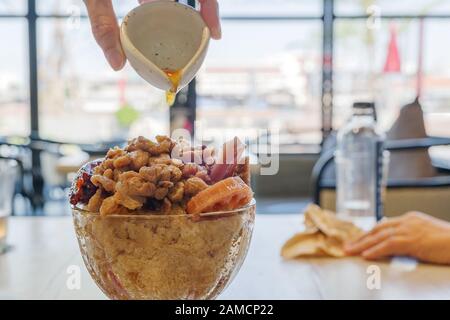 Fusion de dessert doux asiatique coréen et chinois, Sorte de dessert chinois avec racine de Lotus, jujube sec et longan frais sur le dessert coréen Bingsu glacé. Banque D'Images