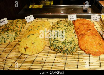 Étals de restauration vendant des crêpes salées de juin à la Corée dans le marché alimentaire animé de Tsuruhashi, Osaka. Banque D'Images