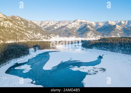 Vue aérienne d'un lac bleu et vert avec neige en hiver dans les montagnes de l'Altaï en Russie. Nature et lieux pittoresques. Banque D'Images