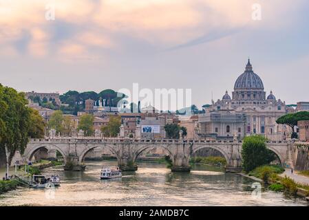 Vue sur le coucher du soleil sur la basilique Saint-Pierre, le Ponte Sant'Angelo et la rivière Tiber à Rome, en Italie Banque D'Images