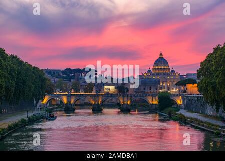 Vue sur le coucher du soleil sur la basilique Saint-Pierre, le Ponte Sant'Angelo et la rivière Tiber à Rome, en Italie Banque D'Images