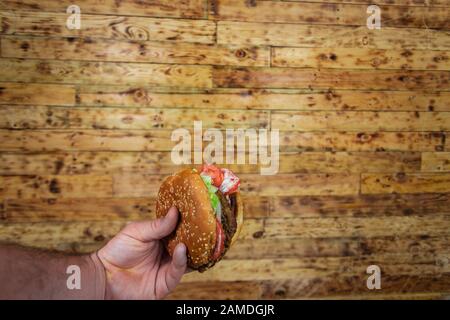 Les mains de l'homme, la maintenant sur un burger Banque D'Images