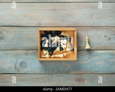 Pièces des échecs dans une boîte en bois avec le roi en dehors de la boîte Banque D'Images