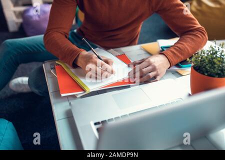 L'étudiant écrit dans son carnet tout en se préparant à l'examen Banque D'Images